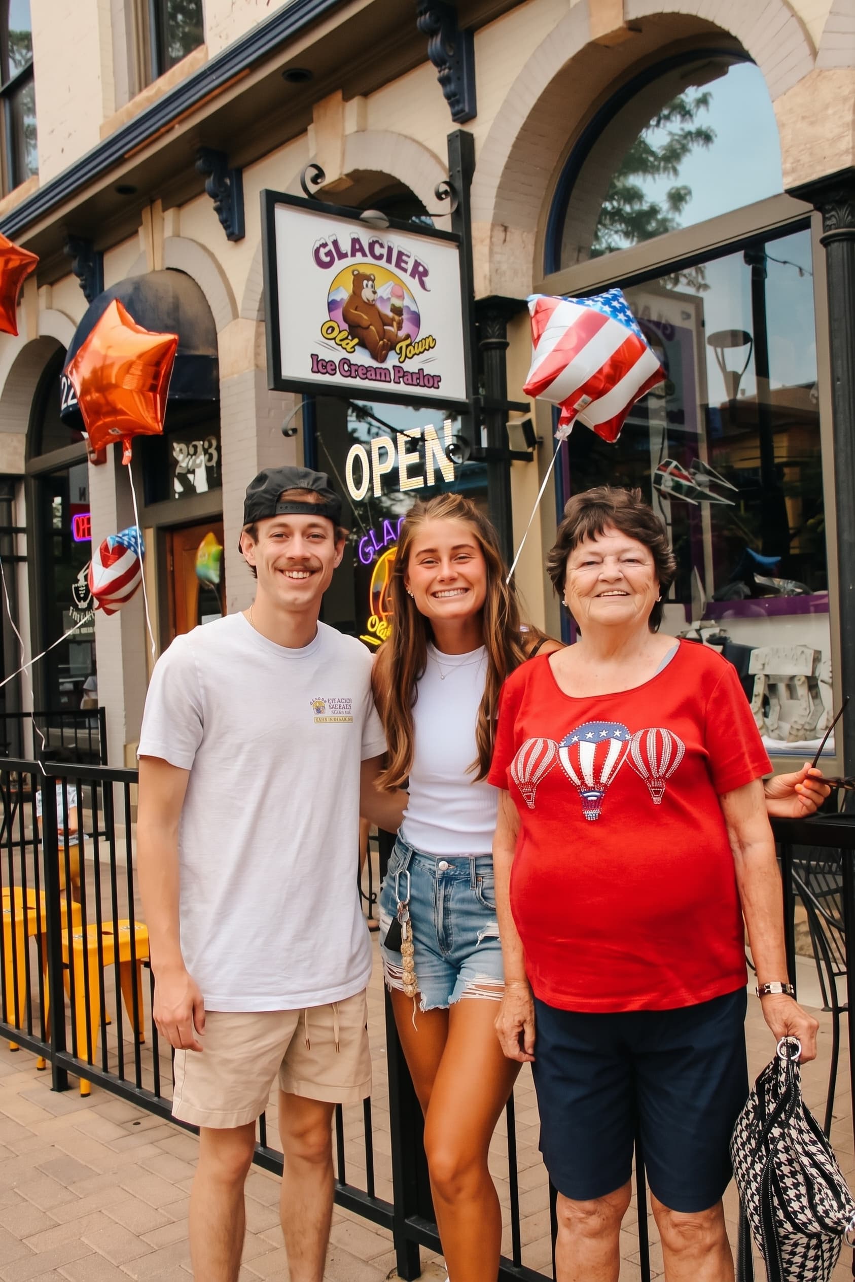 Family posing under the Glacier sign at the front door on opening day