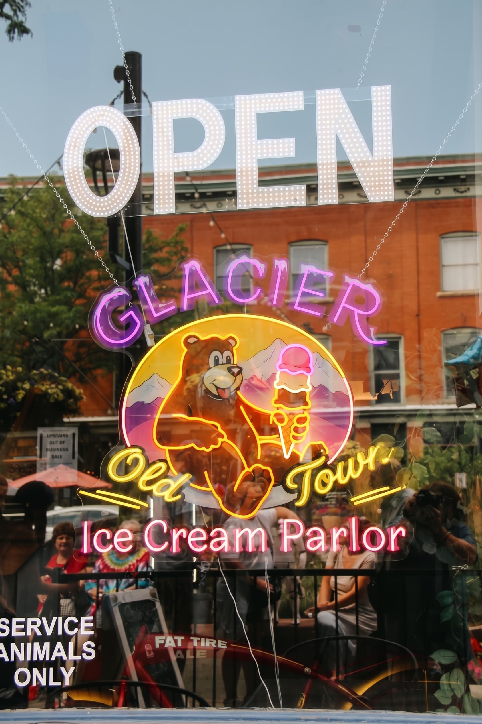 The neon Glacier Old Town window sign glowing behind the OPEN letters