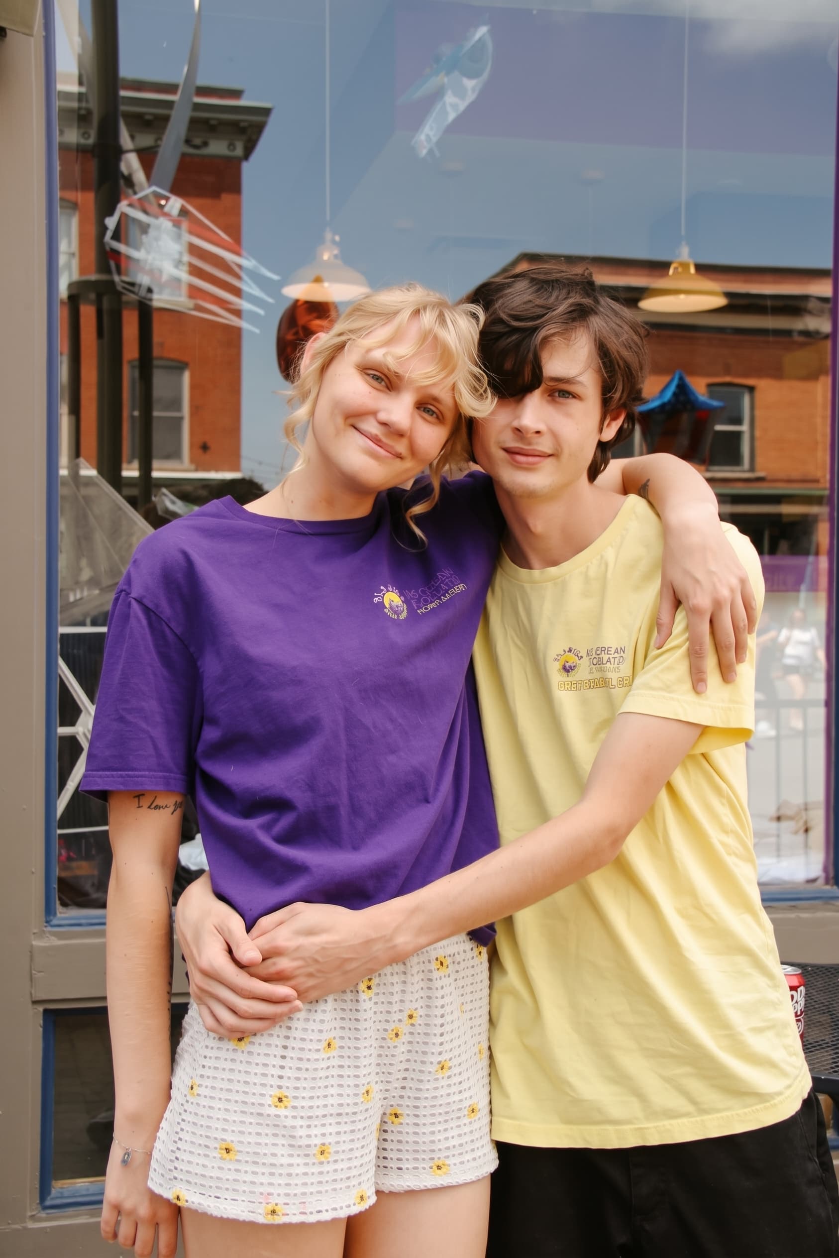 Two friends in Glacier crew shirts outside the parlor windows