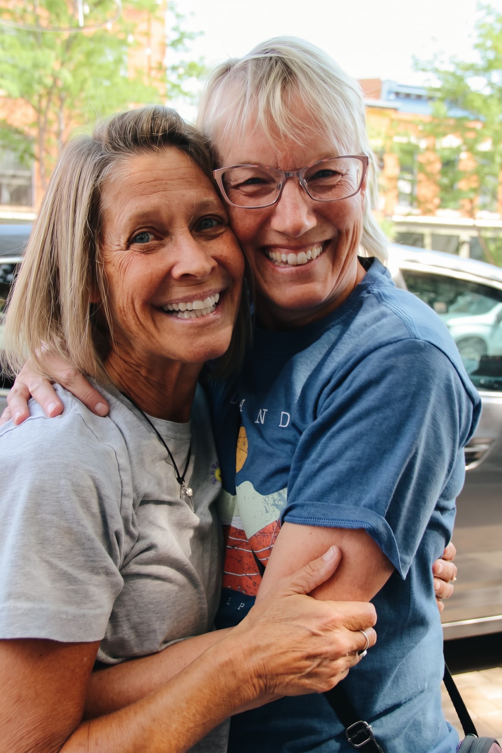 Old friends embracing on the sidewalk outside Glacier