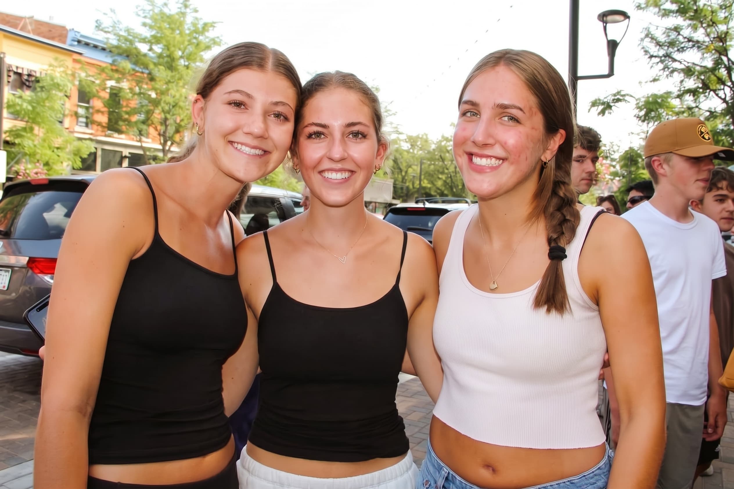 Three friends smiling in the opening-day crowd