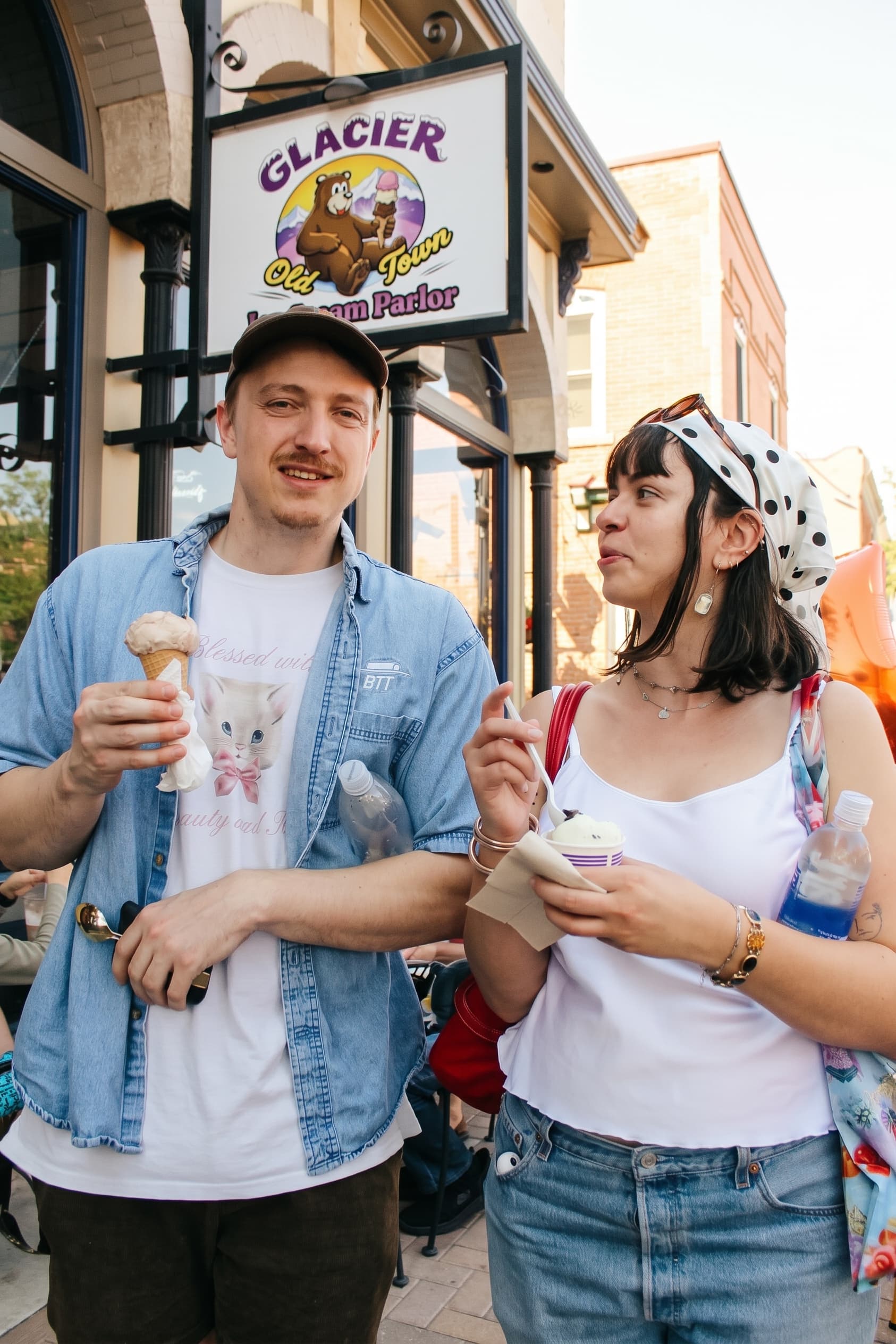 A couple with cones under the Glacier sign on Linden Street
