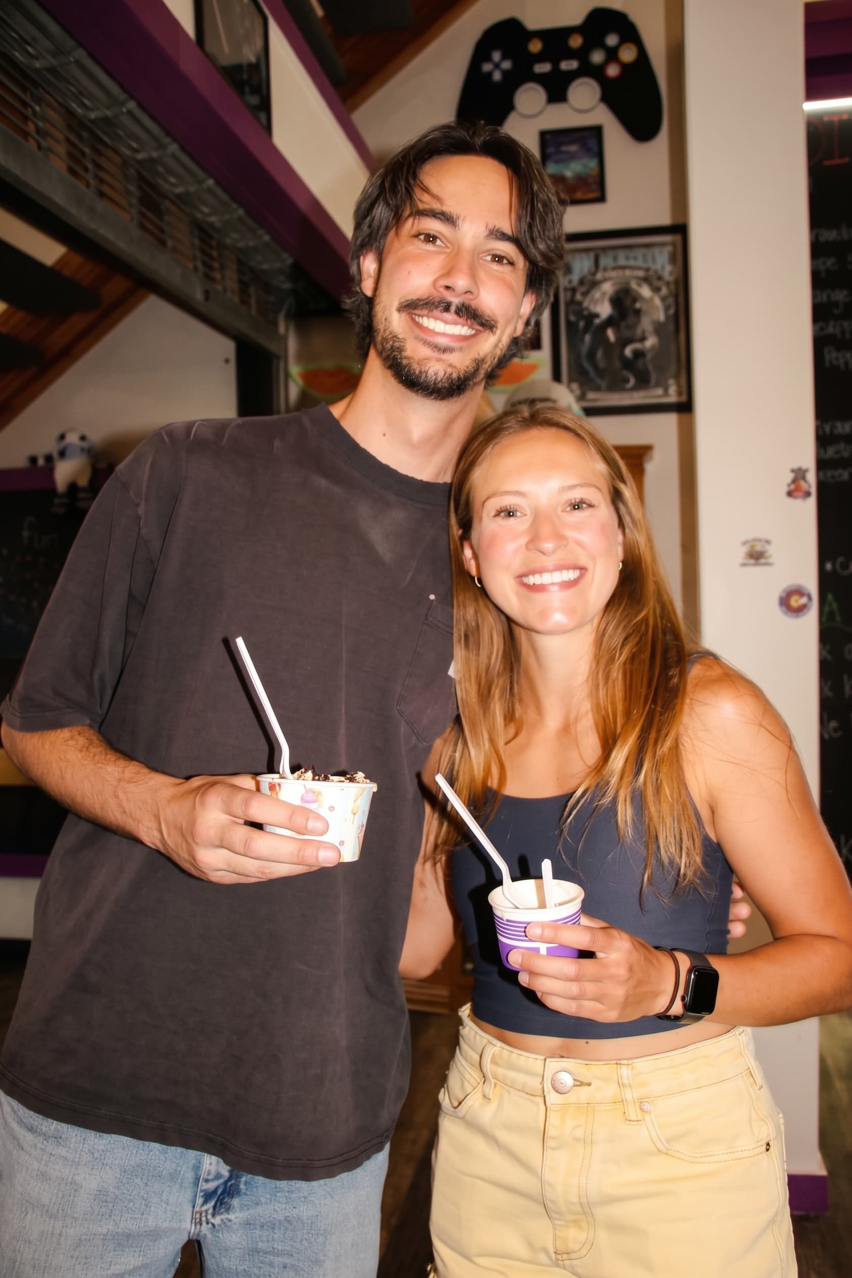 A couple sharing cups of gelato inside the shop