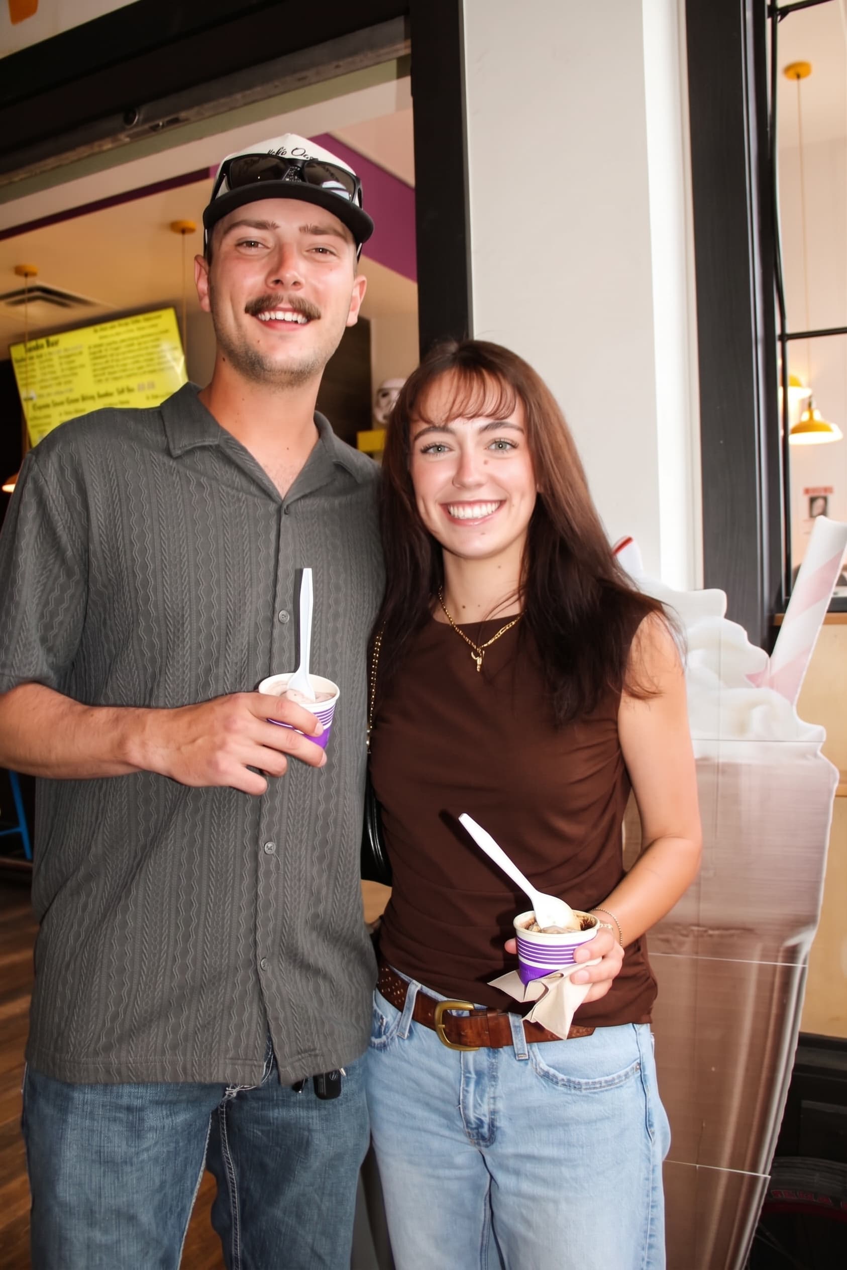 A couple with gelato cups by the front window