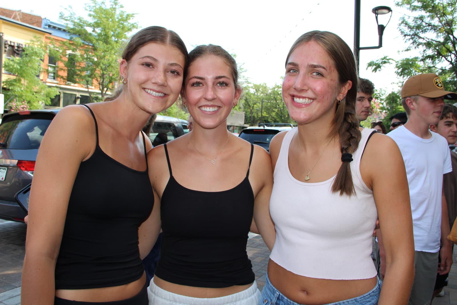 Three friends smiling in the opening-day crowd