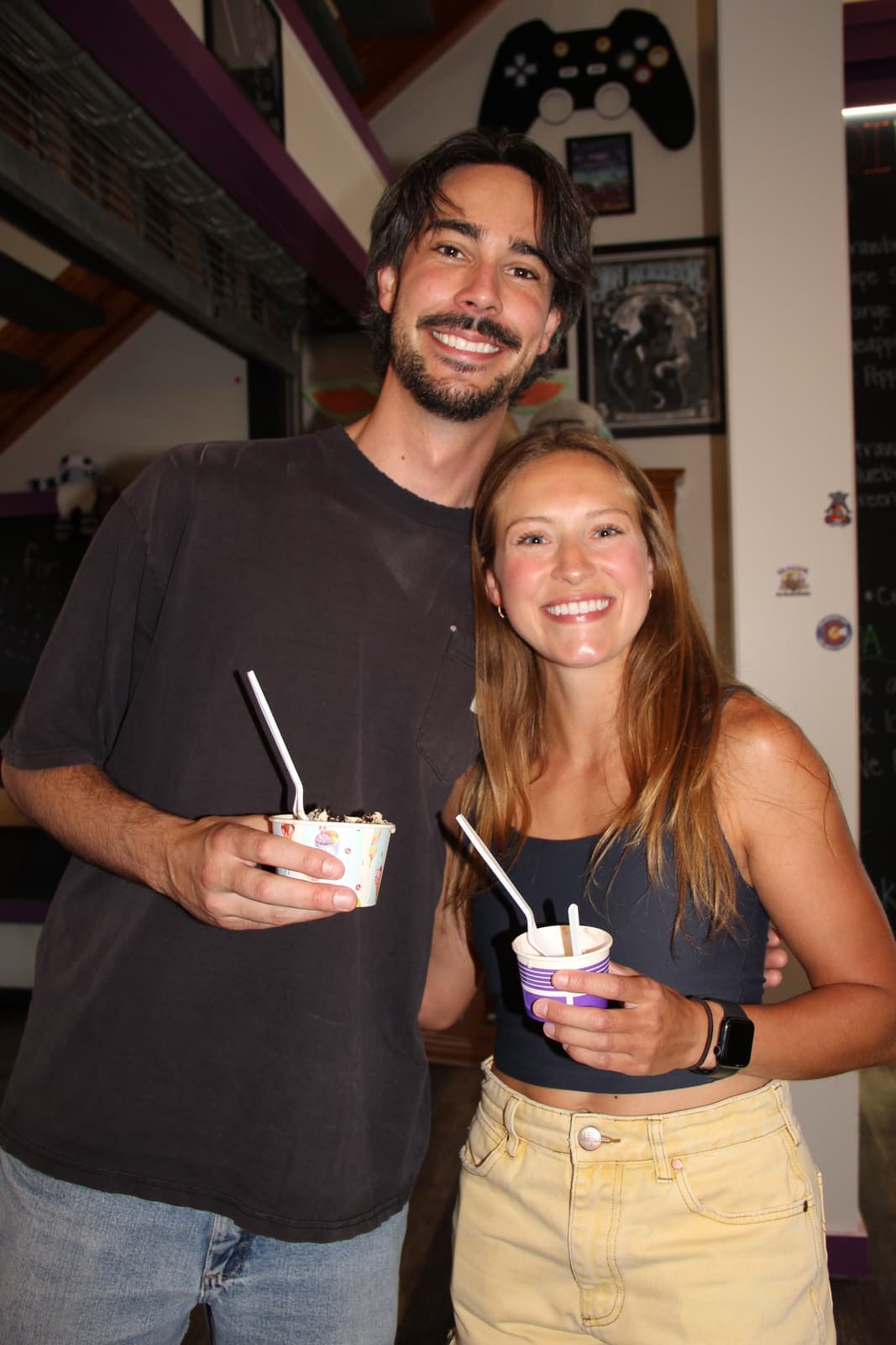 A couple sharing cups of gelato inside the shop