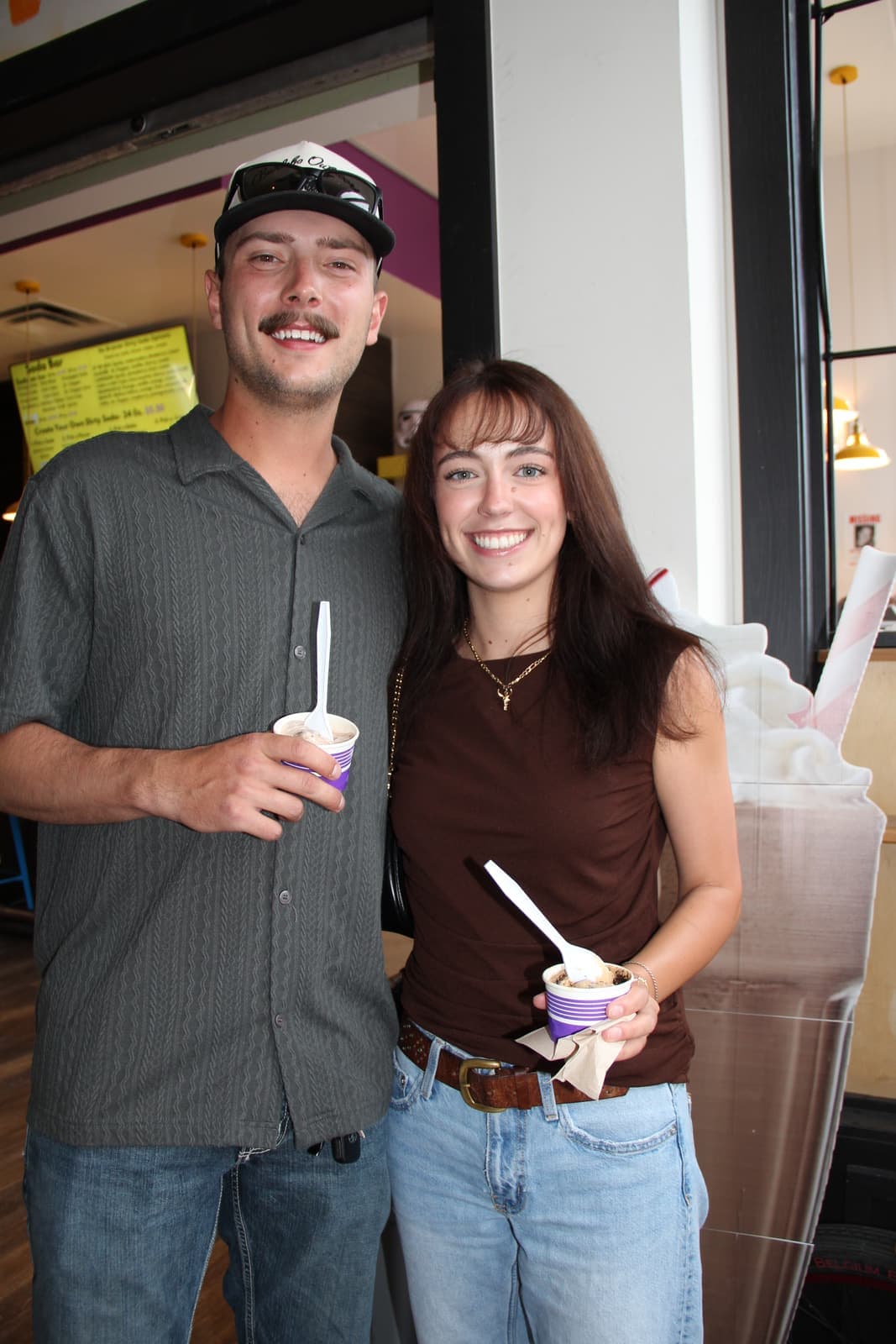 A couple with gelato cups by the front window